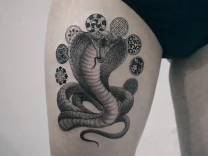 Kobra, bir kızın uyluğundaki dövme